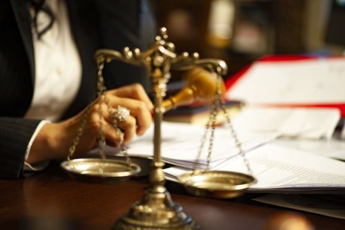 Magistrate with gavel in the background of scales of justice. Pendente Lite hearings concept.