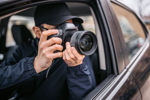 Paparazzi Photographer Taking Photos From Car — divorce private investigator concept.