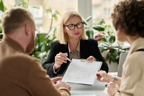 Woman handing contract to couple