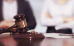 Husband and Wife Judge's Gavel and Wedding Rings with Contested and Consensual Divorce Text